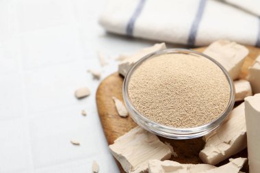 Beyaz fayanslı masada taze ve kuru maya, yakın plan. Metin için boşluk