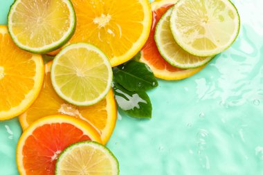 Turkuaz arka planda turkuaz meyveler ve yeşil yapraklar.