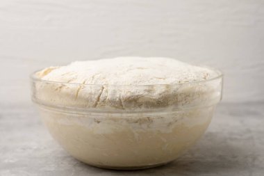 Gri desenli masada cam kasede taze maya hamuru, yakın plan.