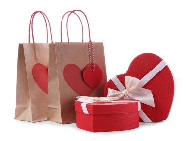 İçinde kalp şeklinde hediye paketleri olan kağıt torbalar beyaza izole edilmiş. Sevgililer Günü