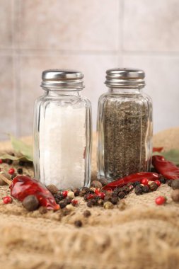 Çuval bezinde baharat olan tuzluk ve biberlikler bulanık arka planda, yakın plan