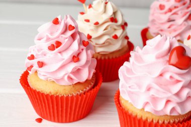 Sevgililer Günün kutlu olsun. Beyaz ahşap masada kalp şeklinde serpiştirilmiş lezzetli kek, yakın plan.