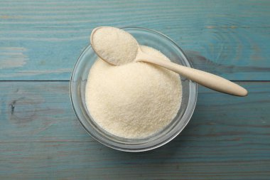 Kasede jelatin tozu ve açık mavi ahşap masa üzerinde kaşık.