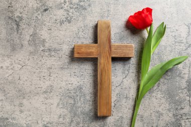 Paskalya özellikleri. Tahta haç ve güzel lale gri masada, düz yerde. Metin için boşluk