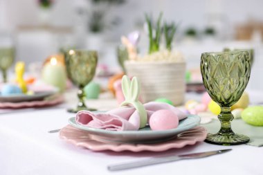 Paskalya kutlaması. Kapalı mekanda boyanmış yumurtalarla şenlik masası, yakın plan.