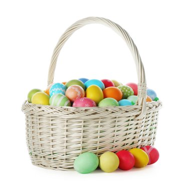 Hasır sepetteki boyanmış Paskalya yumurtaları beyaza izole edilmiş.