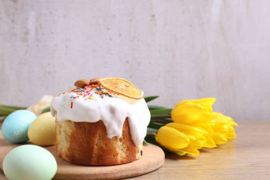 Lezzetli Paskalya pastası, laleler ve boyanmış yumurtalar gri arka planda. Metin için boşluk