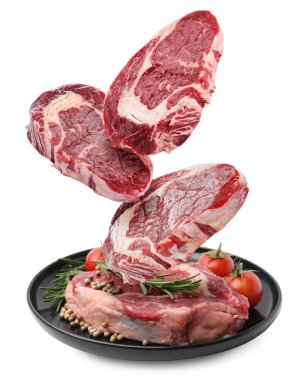 Beyaz arka plana düşen taze biftekler.