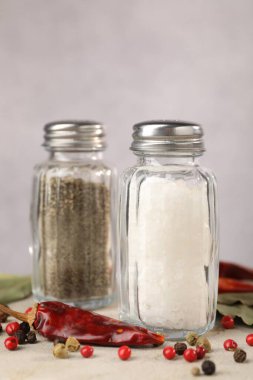 Ahşap masada baharatlı tuzluk ve biberlikler, yakın plan.