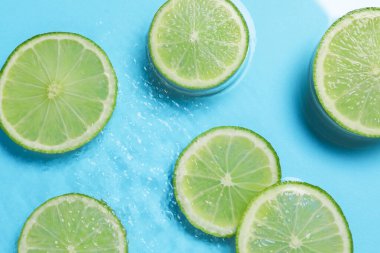 Açık mavi zemin üzerinde limon dilimleri, düz uzanmış.