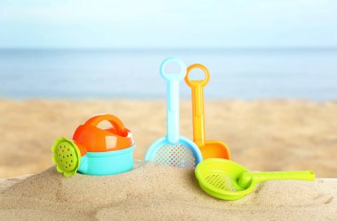 Deniz kenarındaki kumda parlak plastik plaj oyuncakları. Yaz zamanı.