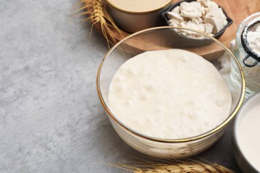 Çiğ hamur, malzemeler ve çiviler gri masada, yakın plan. Metin için boşluk