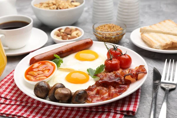 Geleneksel İngiliz kahvaltısı desenli gri masada servis edilir, yakın plan.