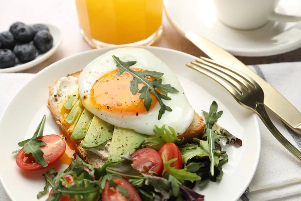 Avokado tostlu sağlıklı bir kahvaltı. Işık masasında servis edilir. Yakın plan.