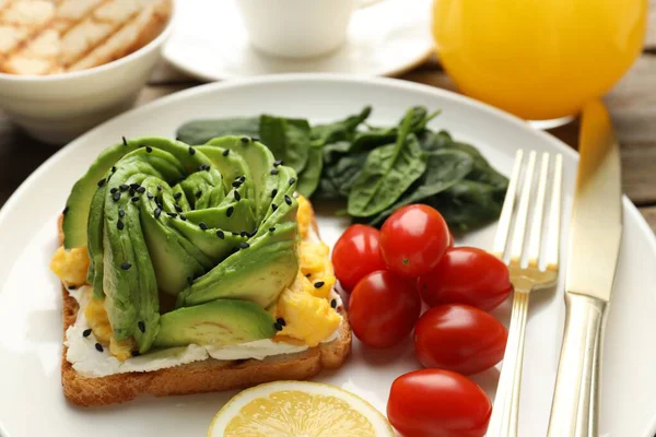 Avokado tostlu lezzetli bir kahvaltı, masada servis edilir, yakın plan.