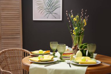 Paskalya kutlaması. Zarif bulaşık takımları ve boyalı yumurtalarla şölen masası.