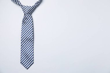 Beyaz arka planda şık çizgili bir kravat, üst manzara. Metin için boşluk