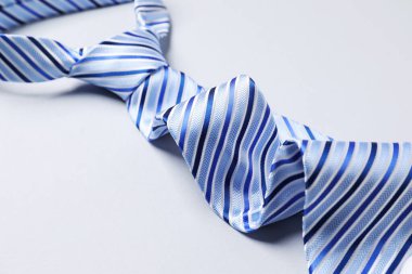 Beyaz arka planda şık çizgili bir kravat, yakın plan.