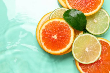 Turkuaz arka planda turkuaz meyveler ve yeşil yaprak dilimleri. Metin için boşluk