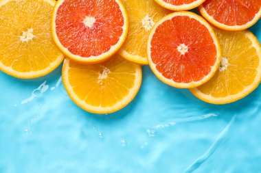 Açık mavi zemin üzerinde su içinde narenciye dilimleri, düz yatıyordu. Metin için boşluk