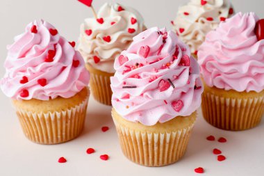 Sevgililer Günün kutlu olsun. Açık gri arka planda serpiştirilmiş lezzetli kekler, yakın plan.