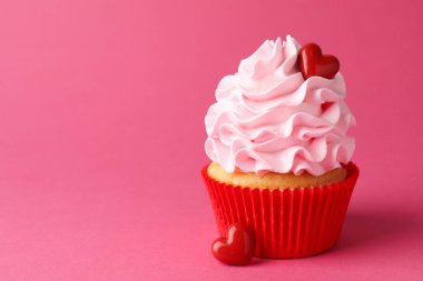 Sevgililer Günün kutlu olsun. Pembe arka planda kırmızı kalpleri olan lezzetli kek, yakın plan. Metin için boşluk