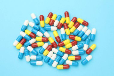 Açık mavi arka planda haplar, düz uzanma