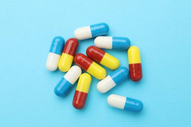 Açık mavi arka planda haplar, düz uzanma