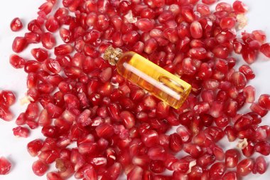 Beyaz zemin üzerinde gerekli yağ ve nar tohumları, üst görünüm