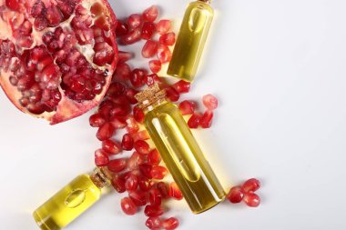 Beyaz arka planda gerekli yağ, nar ve tohumlar, düz bir zemin. Metin için boşluk