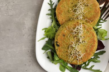 Mikroyeşillikli lezzetli vejetaryen köfteler ve gri masada salata.