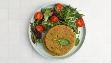 Beyaz fayanslı masada salatalı lezzetli vejetaryen köfteleri.