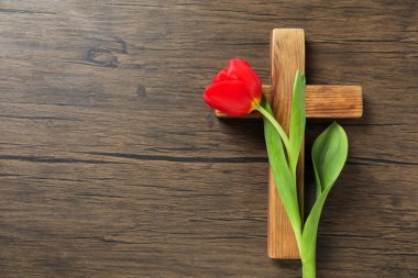 Paskalya özellikleri. Ahşap masada haç ve güzel lale, üst manzara. Metin için boşluk