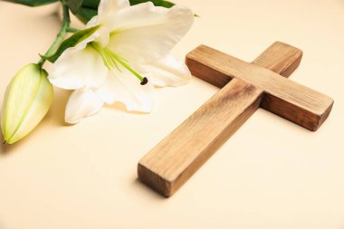 Paskalya. Ahşap haç ve bej arka planda güzel zambak çiçekleri, yakın plan.