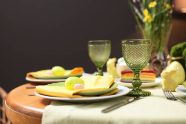 Paskalya kutlaması. Zarif bulaşık takımları ve boyalı yumurtalarla şenlik masası, yakın plan.