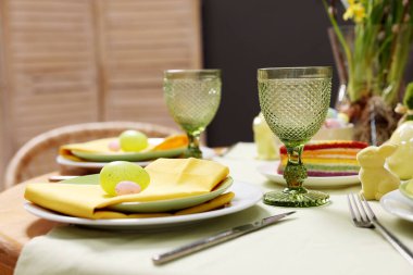 Paskalya kutlaması. Zarif bulaşık takımları ve boyalı yumurtalarla şenlik masası, yakın plan.