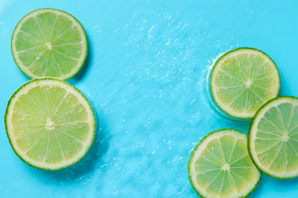 Açık mavi arka planda limon dilimleri, düz bir zemin. Metin için boşluk