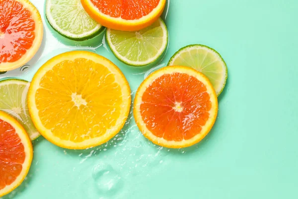 Turkuaz arka planda sudaki narenciye dilimleri, düzlük.