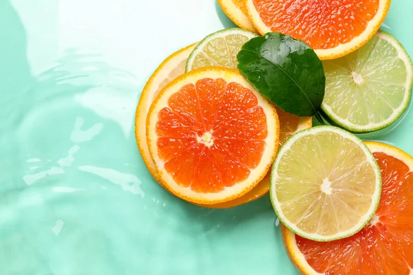 Turkuaz arka planda turkuaz meyveler ve yeşil yaprak dilimleri. Metin için boşluk