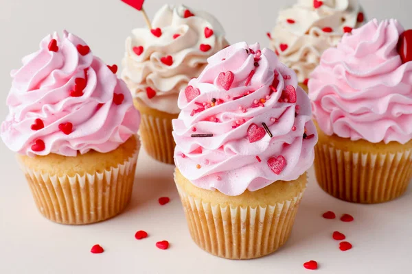 Sevgililer Günün kutlu olsun. Açık gri arka planda serpiştirilmiş lezzetli kekler, yakın plan.