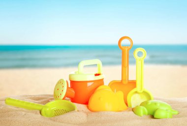 Deniz kenarındaki kumda parlak plastik plaj oyuncakları. Yaz zamanı.