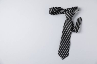 Beyaz arka planda şık çizgili bir kravat, üst manzara. Metin için boşluk