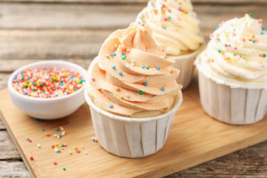 Tahta masaya serpiştirilmiş lezzetli kekler, yakın plan.