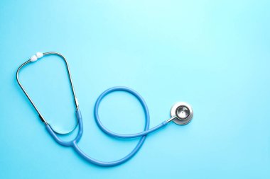Açık mavi arka planda steteskop, üst manzara. Metin için boşluk
