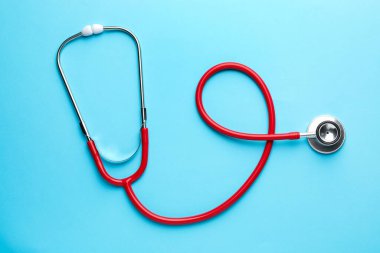 Açık mavi arkaplanda kırmızı steteskop, üst görünüm