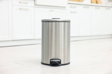 Mutfakta yerde metal çöp kovası.