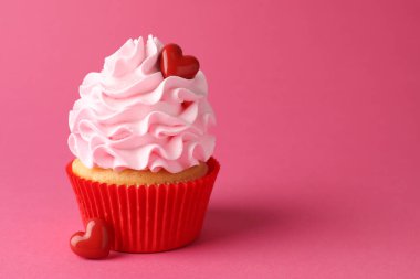 Sevgililer Günün kutlu olsun. Pembe arka planda kırmızı kalpleri olan lezzetli kek, yakın plan. Metin için boşluk