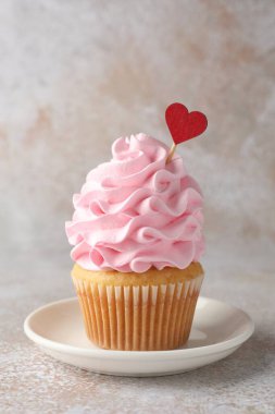 Sevgililer Günün kutlu olsun. Gri masadaki kırmızı kalpli tatlı kek, yakın plan.