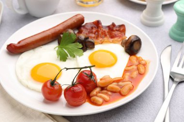 Geleneksel İngiliz kahvaltısı açık gri masada servis edilir, yakın plan.