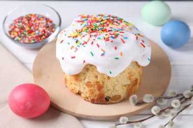 Lezzetli Paskalya pastası, boyanmış yumurtalar ve söğüt dalları beyaz ahşap masada, yakın plan.